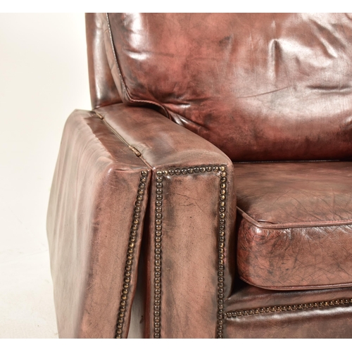 367 - A pair of Knole style brown leather drop-side armchairs. Each armchair having a straight back with w... 