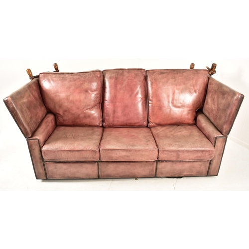 368 - A Knole style brown leather drop-side three seater sofa settee. The sofa having a straight back with... 