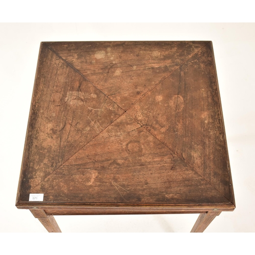 571 - An Edwardian oak & gilt detailed envelope card / game table. The table having a squared folding enve... 