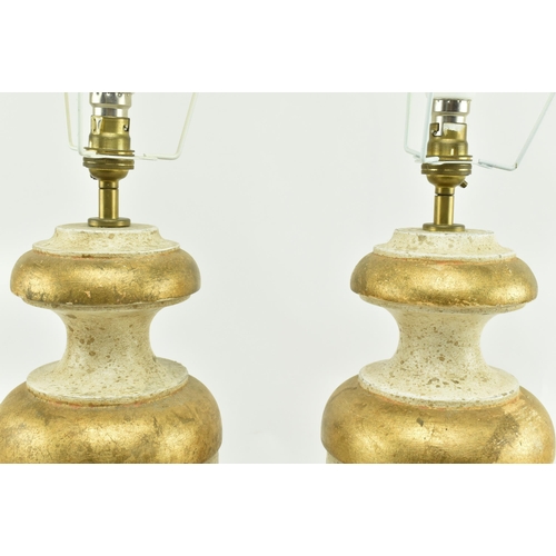 575 - Porta Romana - A pair of gold & cream aged effect wooden desk table lamps in the shape of urns. Each... 