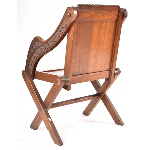 392 - A Victorian 19th century carved oak Glastonbury chair. The chair having a squared frame with shaped ... 