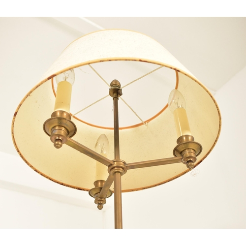 590 - A French inspired brass adjustable floor standard lamp. The lamp having a cream shade over three geo... 