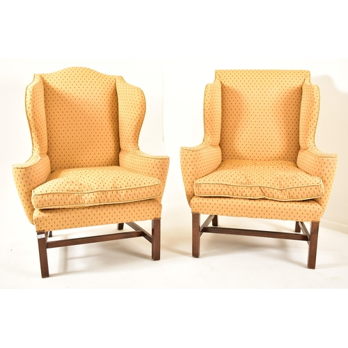 407 - A pair of George III revival mahogany & upholstered wing-back armchairs. Each chair having a winged ... 