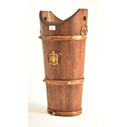 409 - An early 20th century oak staved umbrella / stick stand bucket. The stand having a concave mouth wit... 