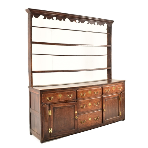 414 - A George III 18th century oak dresser. The dresser having an upright gallery plate rack  with flared... 