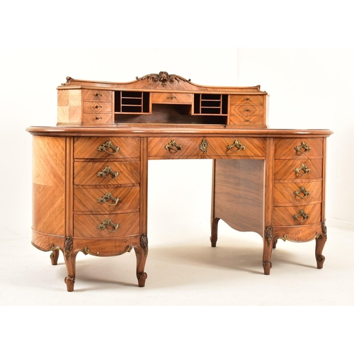 416 - A continental early 20th century walnut crossbanded twin pedestal kidney shaped desk. The desk havin... 