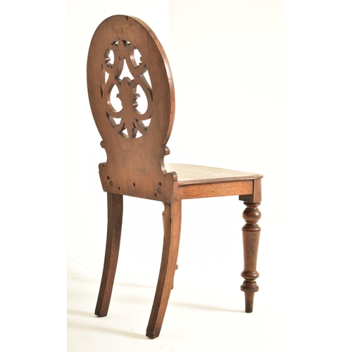 443 - A pair of Victorian 19th century carved oak round back hall chairs. Each chair having a pierced roun... 