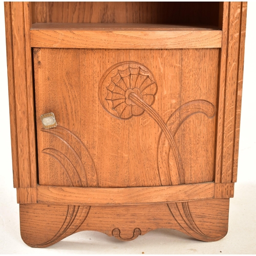 473 - An early to mid 20th century French carved oak bedside cupboard / nightstand. The bedside having a m... 