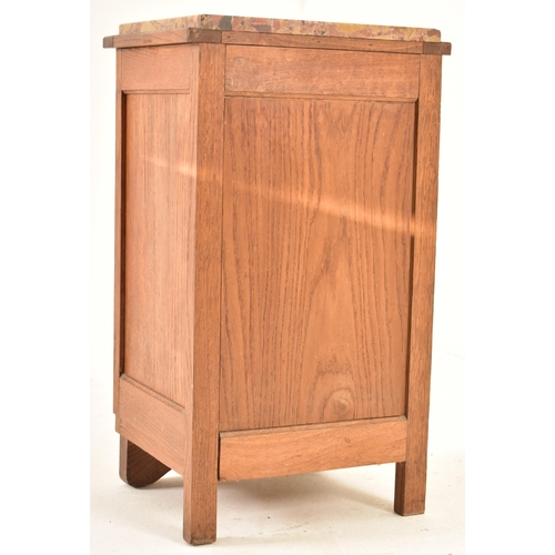 473 - An early to mid 20th century French carved oak bedside cupboard / nightstand. The bedside having a m... 