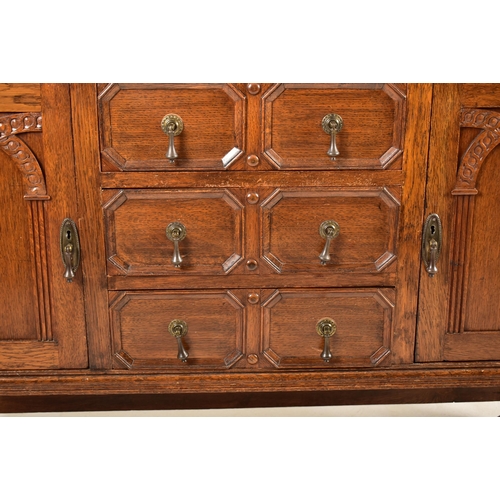 474 - A 1920's Jacobean Revival carved oak buffet cupboard cabinet. The buffet having a pediment top with ... 