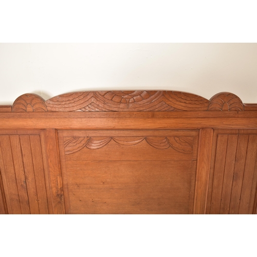 484 - An early to mid 20th century French carved oak double bed. The bed having a panelled oak headboard a... 