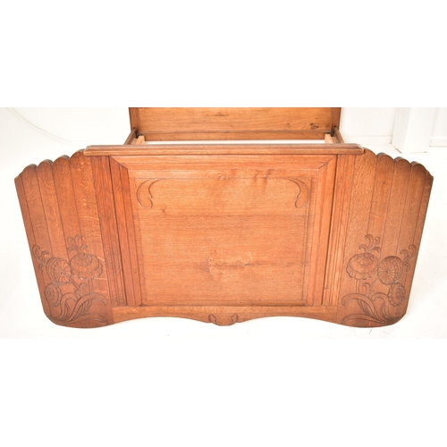 484 - An early to mid 20th century French carved oak double bed. The bed having a panelled oak headboard a... 