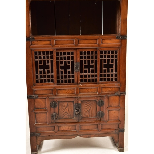 491 - A Japanese early 20th century hardwood upright cupboard cabinet. The cabinet having a flared top ove... 