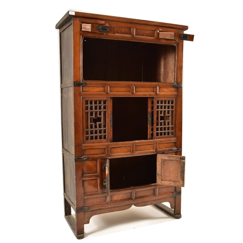 491 - A Japanese early 20th century hardwood upright cupboard cabinet. The cabinet having a flared top ove... 