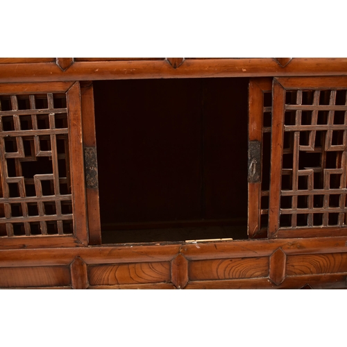 491 - A Japanese early 20th century hardwood upright cupboard cabinet. The cabinet having a flared top ove... 