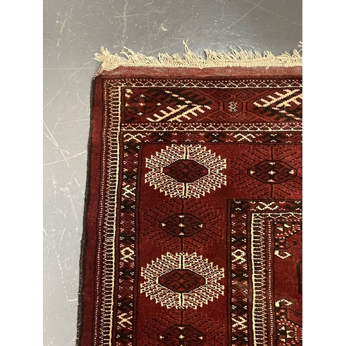 527 - An early 20th century circa 1920s Turkmen Islamic virgin wool floor carpet rug. The rug in burgundy ... 