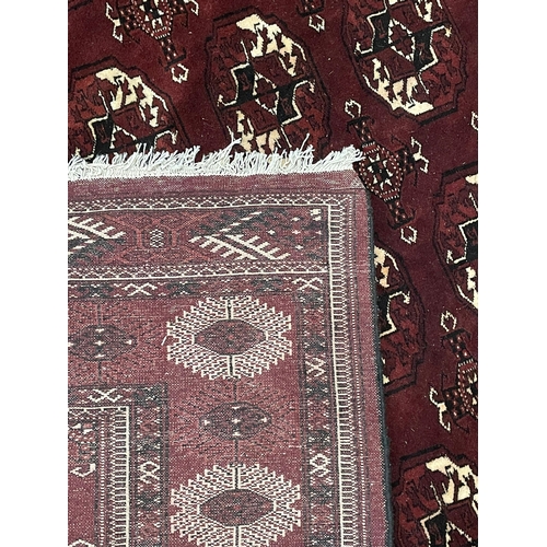 527 - An early 20th century circa 1920s Turkmen Islamic virgin wool floor carpet rug. The rug in burgundy ... 