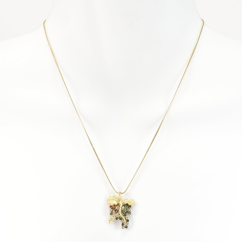 154 - An 18ct gold, emerald and diamond grapevine pendant necklace. The 18ct gold grapevine pendant set wi... 