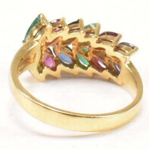 16 - An 18ct gold, emerald, sapphire and ruby cluster ring. The ring having twelve graduating marquis cut... 