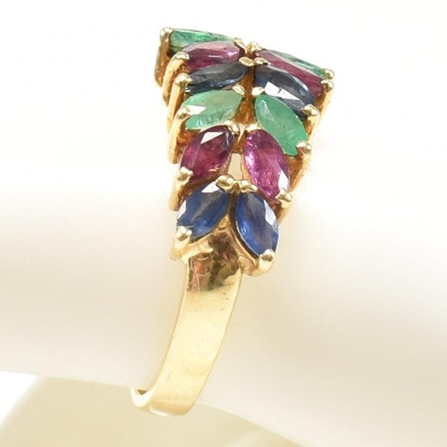 16 - An 18ct gold, emerald, sapphire and ruby cluster ring. The ring having twelve graduating marquis cut... 