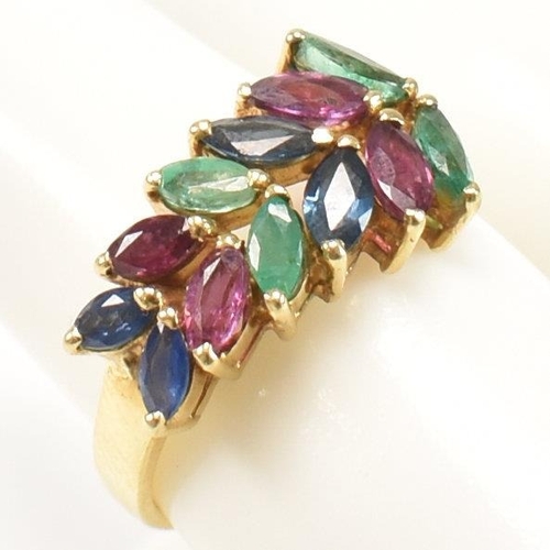 16 - An 18ct gold, emerald, sapphire and ruby cluster ring. The ring having twelve graduating marquis cut... 