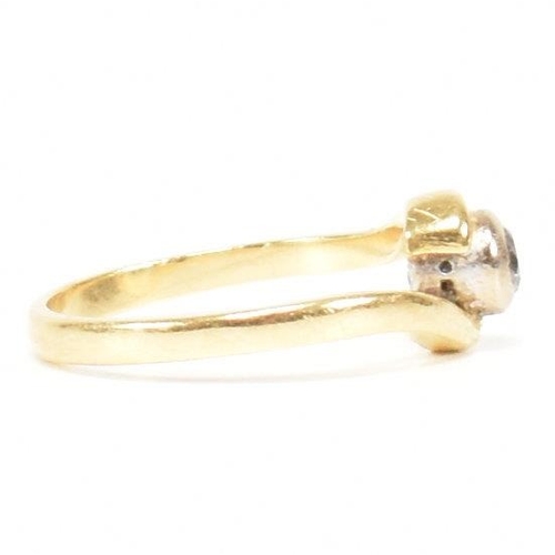 261 - A hallmarked 18ct gold and diamond crossover ring. The ring set with a bezel set central round brill... 