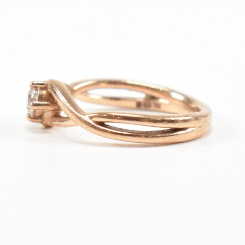 297 - A hallmarked 9ct rose gold and white stone solitaire crossover ring. The single stone engagement sty... 