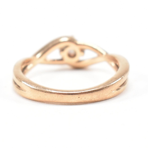 297 - A hallmarked 9ct rose gold and white stone solitaire crossover ring. The single stone engagement sty... 