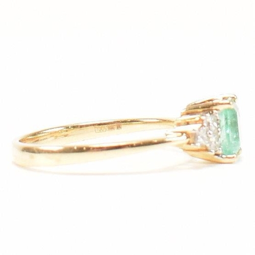 42 - A hallmarked 18ct gold emerald & diamond ring. The ring set with a central emerald flanked by two tr... 