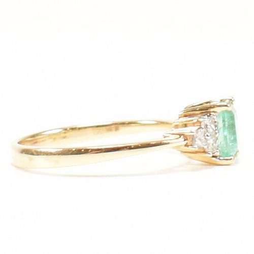 42 - A hallmarked 18ct gold emerald & diamond ring. The ring set with a central emerald flanked by two tr... 