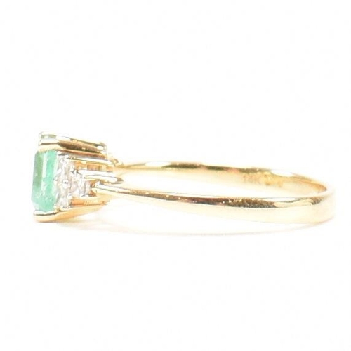 42 - A hallmarked 18ct gold emerald & diamond ring. The ring set with a central emerald flanked by two tr... 