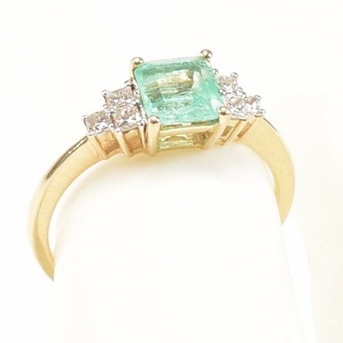 42 - A hallmarked 18ct gold emerald & diamond ring. The ring set with a central emerald flanked by two tr... 