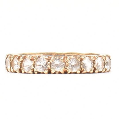 454 - A 9ct gold and spinel eternity ring. The eternity ring set with a row of round cut spinels. Stamped ... 