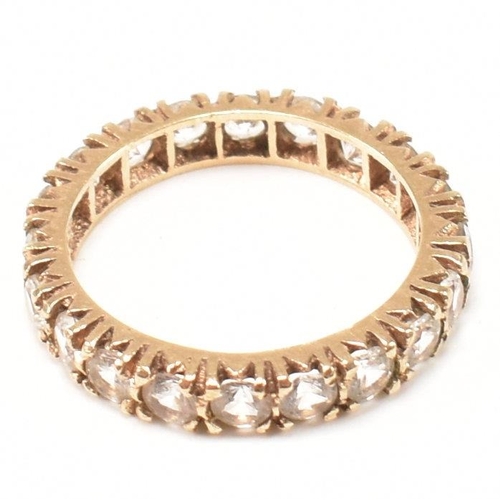 454 - A 9ct gold and spinel eternity ring. The eternity ring set with a row of round cut spinels. Stamped ... 