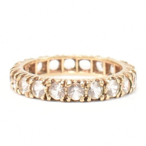 454 - A 9ct gold and spinel eternity ring. The eternity ring set with a row of round cut spinels. Stamped ... 