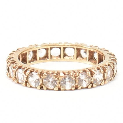 454 - A 9ct gold and spinel eternity ring. The eternity ring set with a row of round cut spinels. Stamped ... 