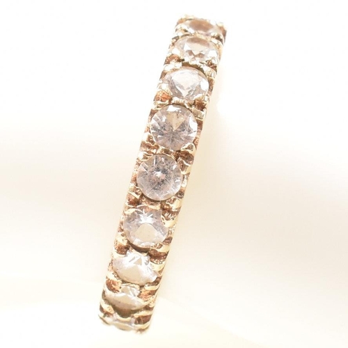 454 - A 9ct gold and spinel eternity ring. The eternity ring set with a row of round cut spinels. Stamped ... 