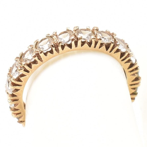 454 - A 9ct gold and spinel eternity ring. The eternity ring set with a row of round cut spinels. Stamped ... 