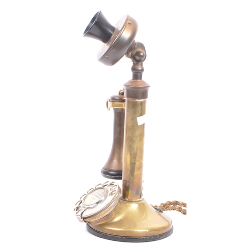 309 - An early 20th century brass candlestick telephone. The telephone of brass construction with black ba... 