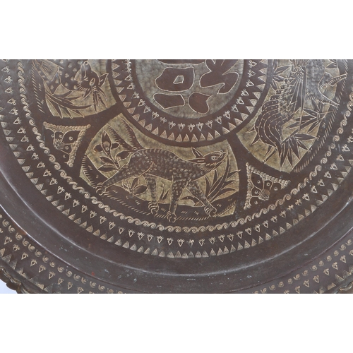 380 - A 20th century Chinese brass wall charger wall mounted tray. The charger having central Chinese char... 