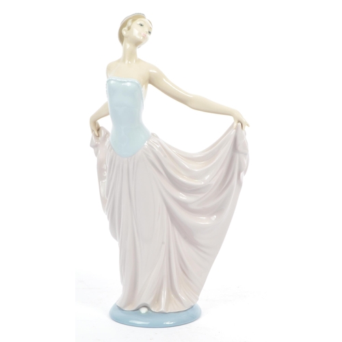 100 - Lladro - A vintage 20th century porcelain china figure. Depicting a woman with long flowing dress an... 