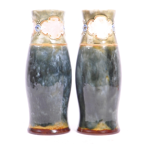 11 - A pair of early 20th century circa. 1920s Doulton Lambeth vases. The vases having a green glaze, wit... 