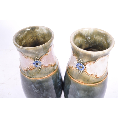 11 - A pair of early 20th century circa. 1920s Doulton Lambeth vases. The vases having a green glaze, wit... 