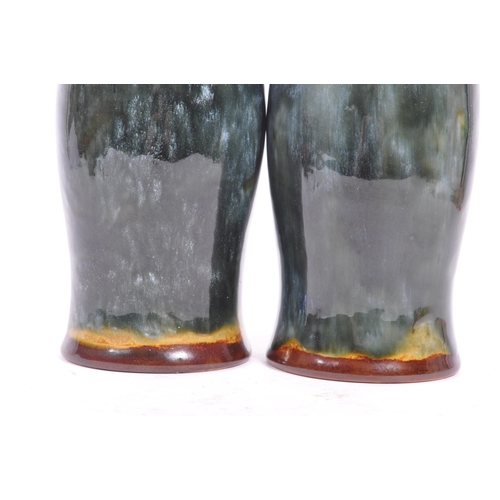 11 - A pair of early 20th century circa. 1920s Doulton Lambeth vases. The vases having a green glaze, wit... 