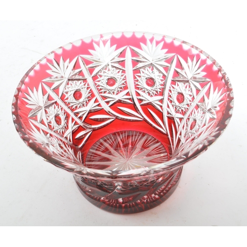 147 - Two cut glass lead crystal cranberry colour dishes along with a gilt lidded pot. Both dishes of simi... 