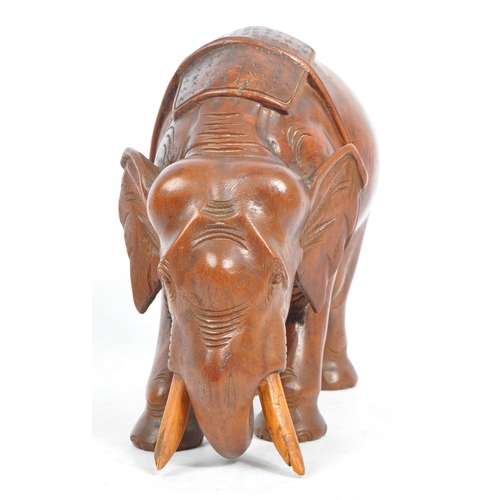 184 - An Indian inspired Oriental hand carved hardwood sculpture figure of elephant with tusks. The elepha... 