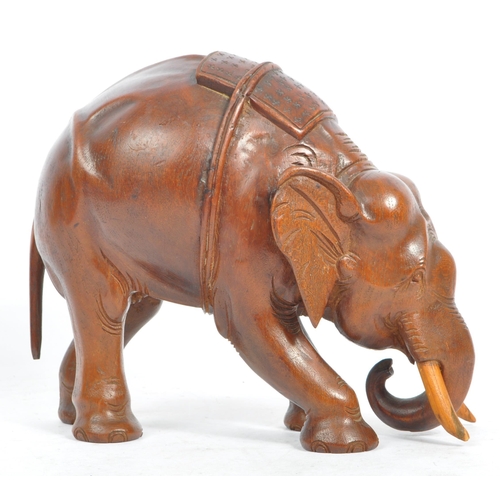 184 - An Indian inspired Oriental hand carved hardwood sculpture figure of elephant with tusks. The elepha... 