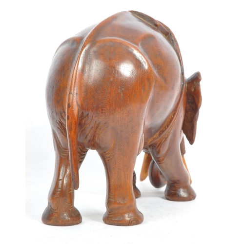 184 - An Indian inspired Oriental hand carved hardwood sculpture figure of elephant with tusks. The elepha... 