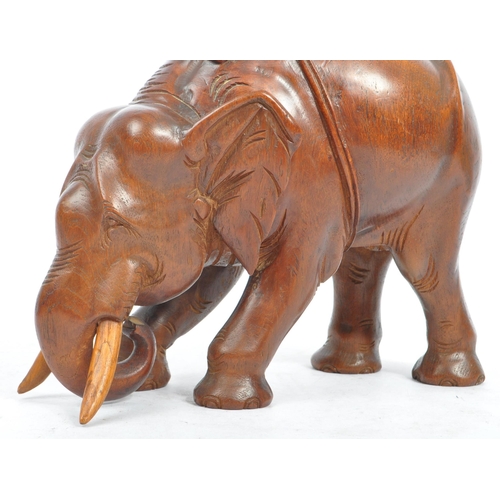 184 - An Indian inspired Oriental hand carved hardwood sculpture figure of elephant with tusks. The elepha... 