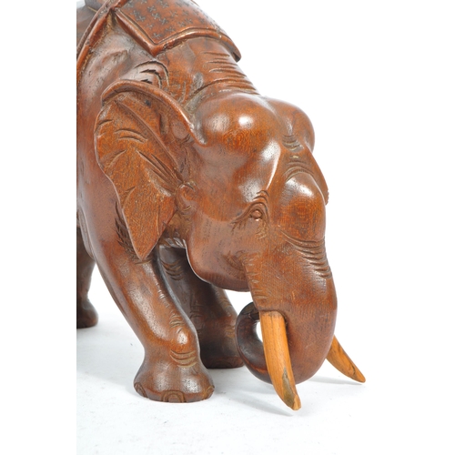 184 - An Indian inspired Oriental hand carved hardwood sculpture figure of elephant with tusks. The elepha... 